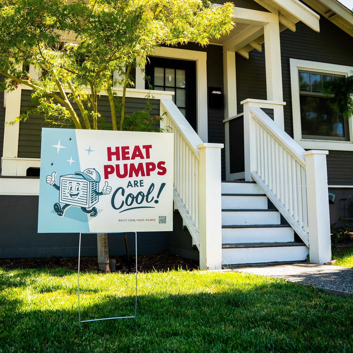 Promotional sign for heat pumps in front of a house