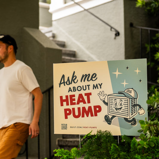 Person walking past a sign about heat pumps with a cartoon character on it.
