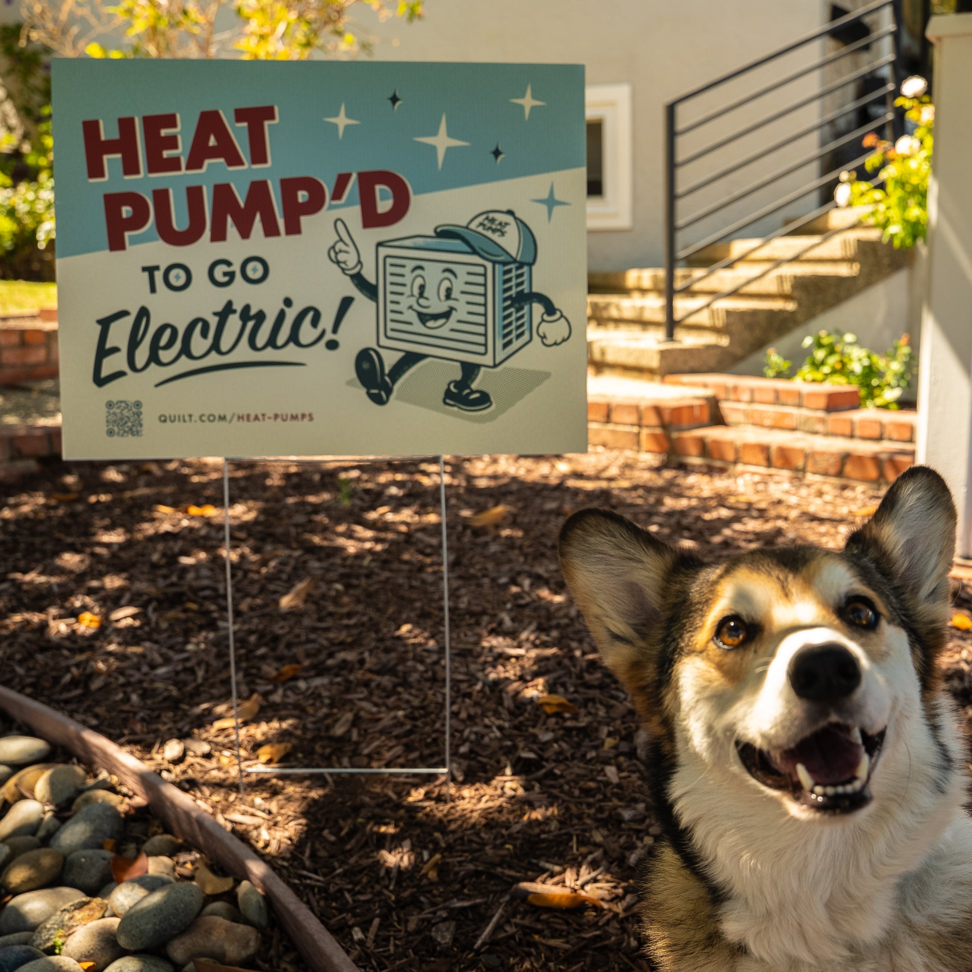 Dog in front of a 'Heat Pump'd to Go Electric!' sign in a garden setting