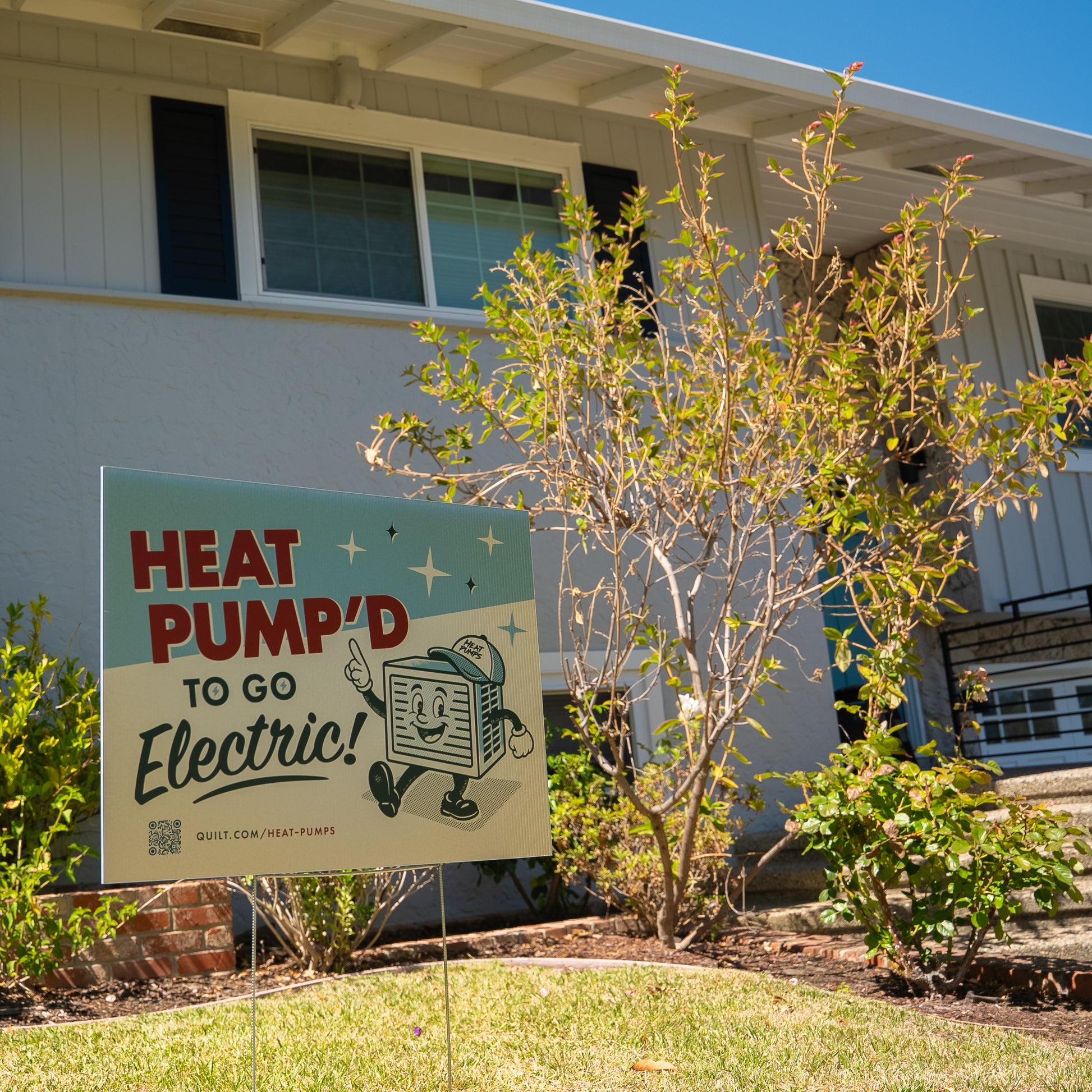Promotional sign for heat pump electric system in front of a house
